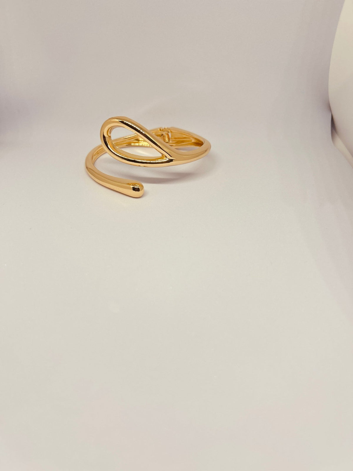 Flat lay of Golden Infinity Loop Cuff Bracelet – Timeless Elegance - CharmsCrafted